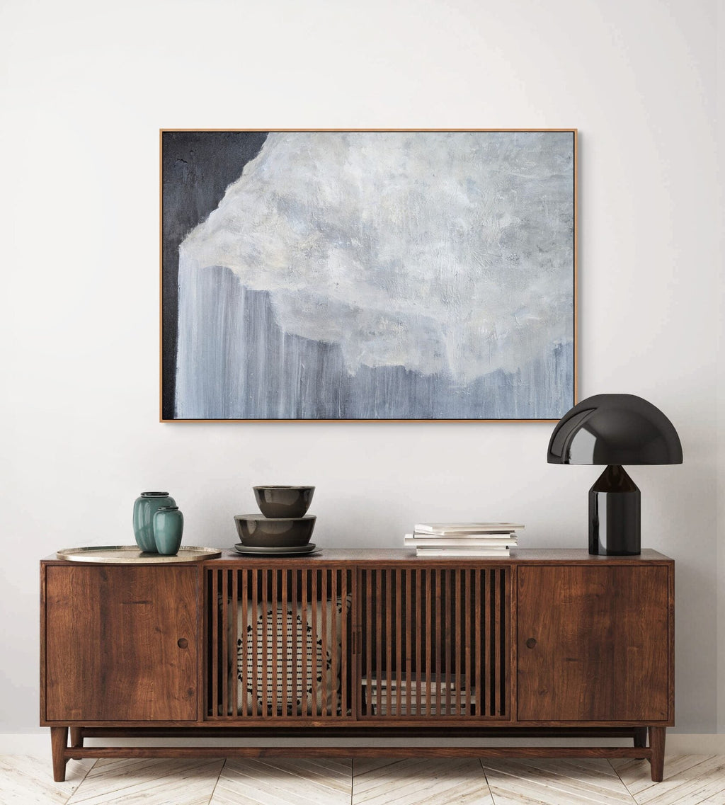 Wooden sideboard with decorative items and a large abstract painting on the wall.