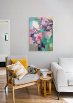 Modern living room with a colorful abstract painting on the wall, a chair with cushions, and a sofa.