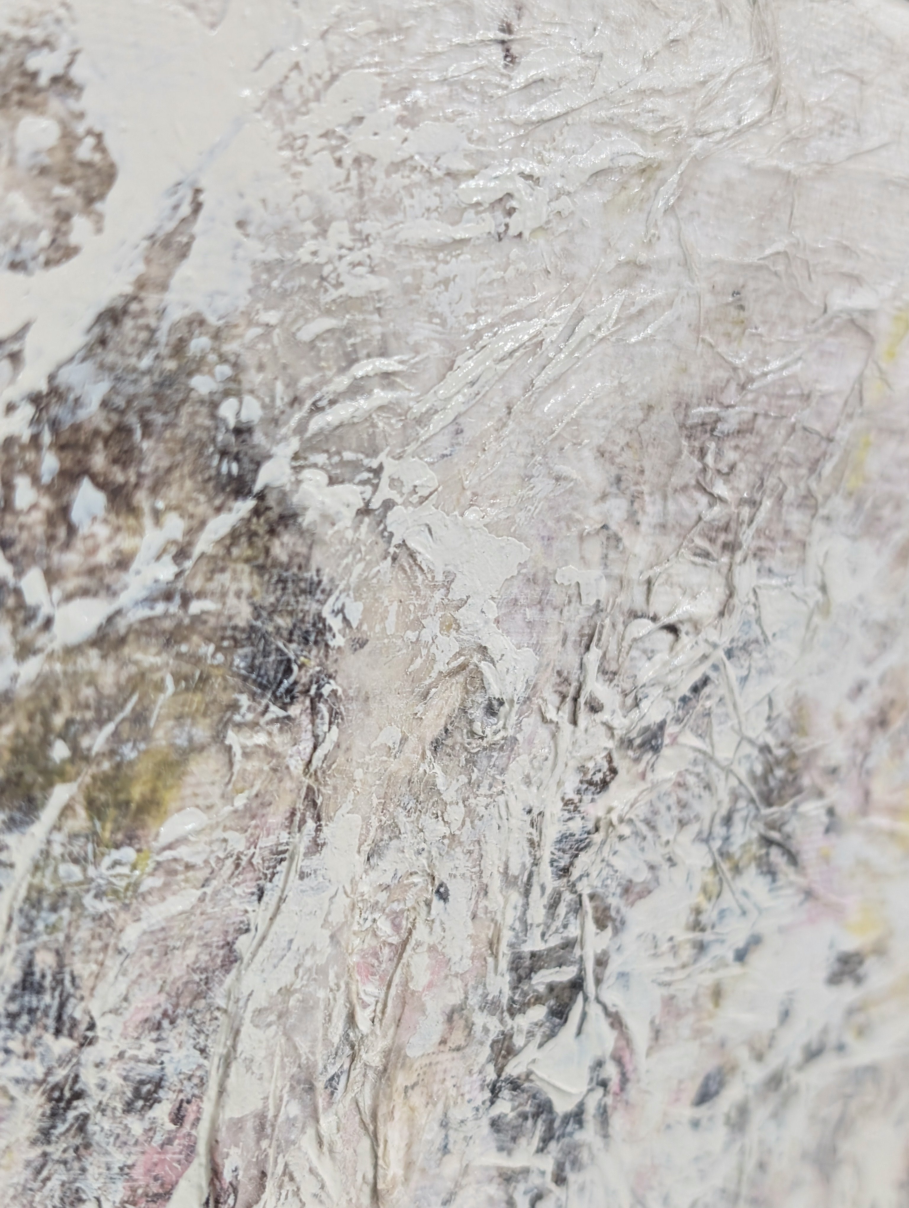 Close-up of a textured stone surface with beige, brown, and gray tones.