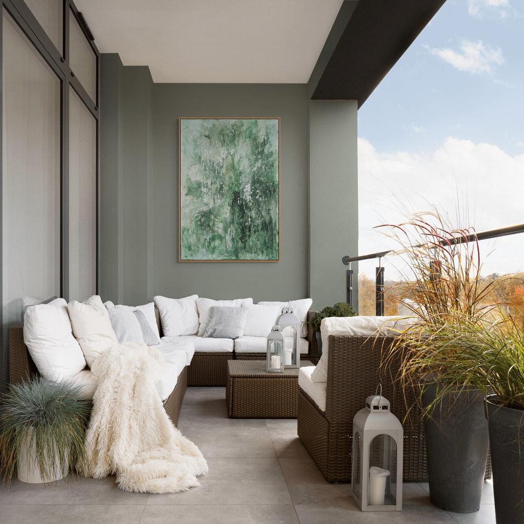 Modern outdoor living space with a sectional sofa, potted plants, and a painting on a wall.