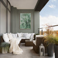 Modern outdoor living space with a sectional sofa, potted plants, and a painting on a wall.
