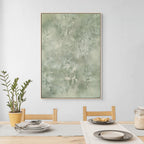 Dining room with a large abstract green painting on the wall, a plant, and a table setting.