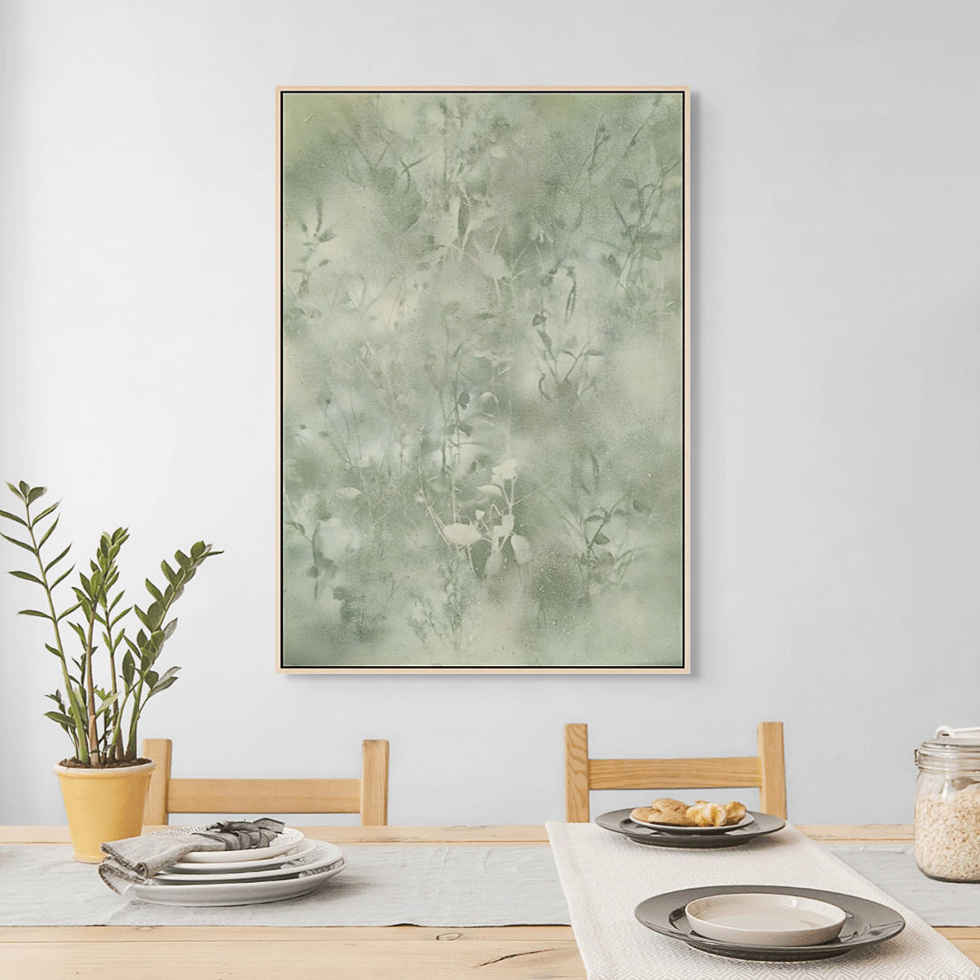 Dining room with a large abstract green painting on the wall, a plant, and a table setting.
