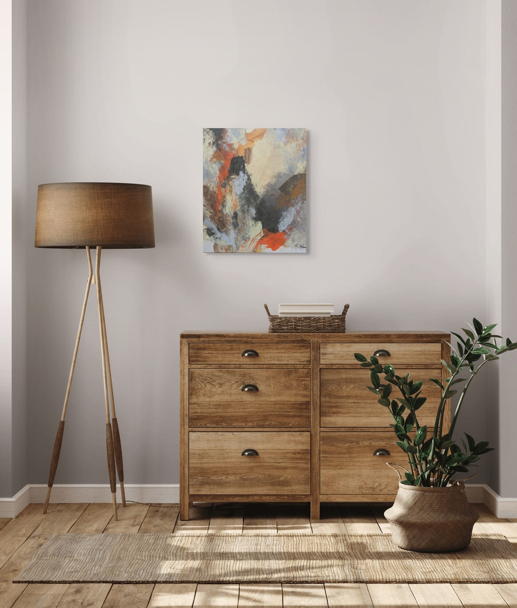 Wooden dresser with a lamp, plant, and abstract painting in a room.