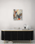 Abstract painting on a wall above a black and gold sideboard with decorative items.