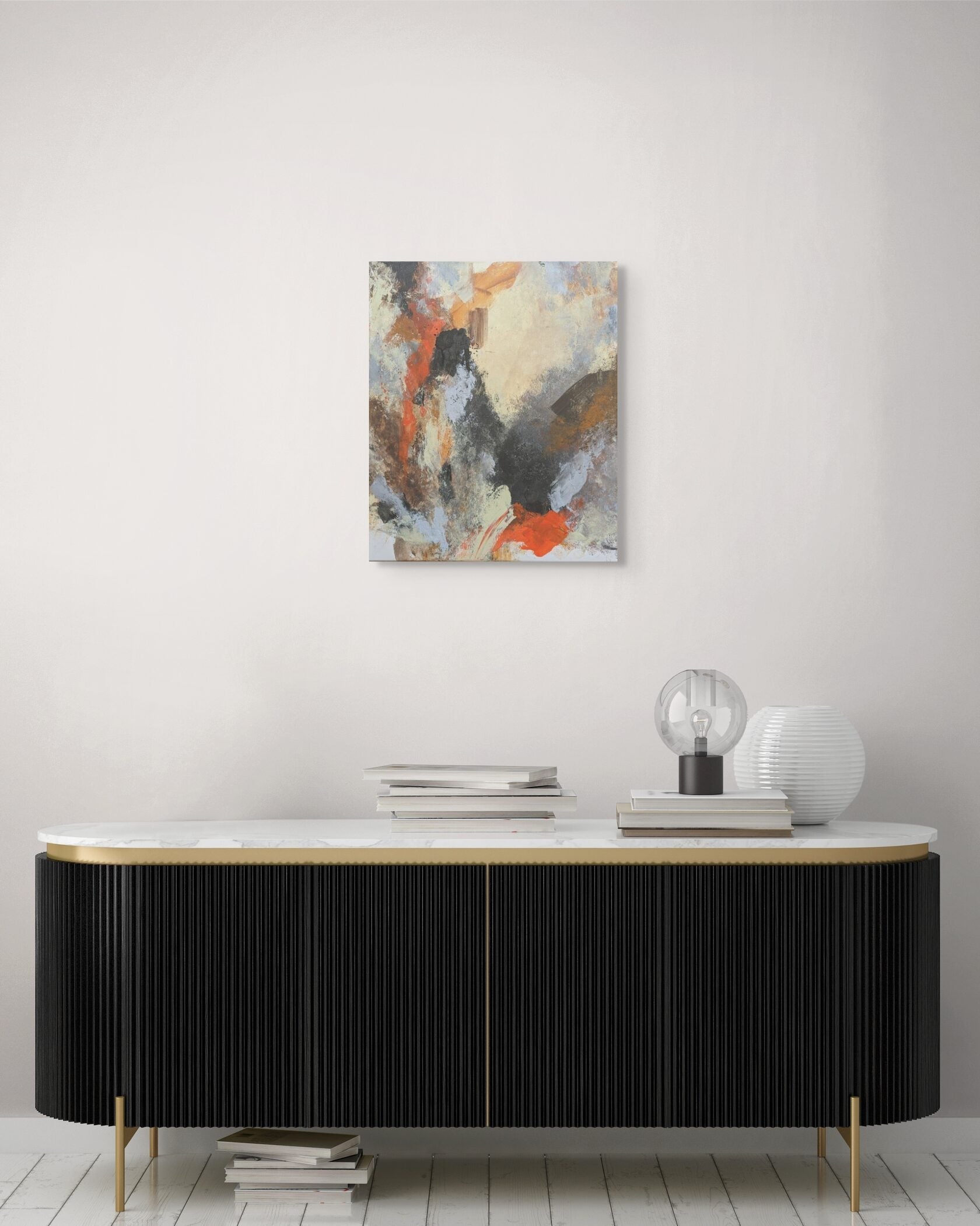Abstract painting on a wall above a black and gold sideboard with decorative items.