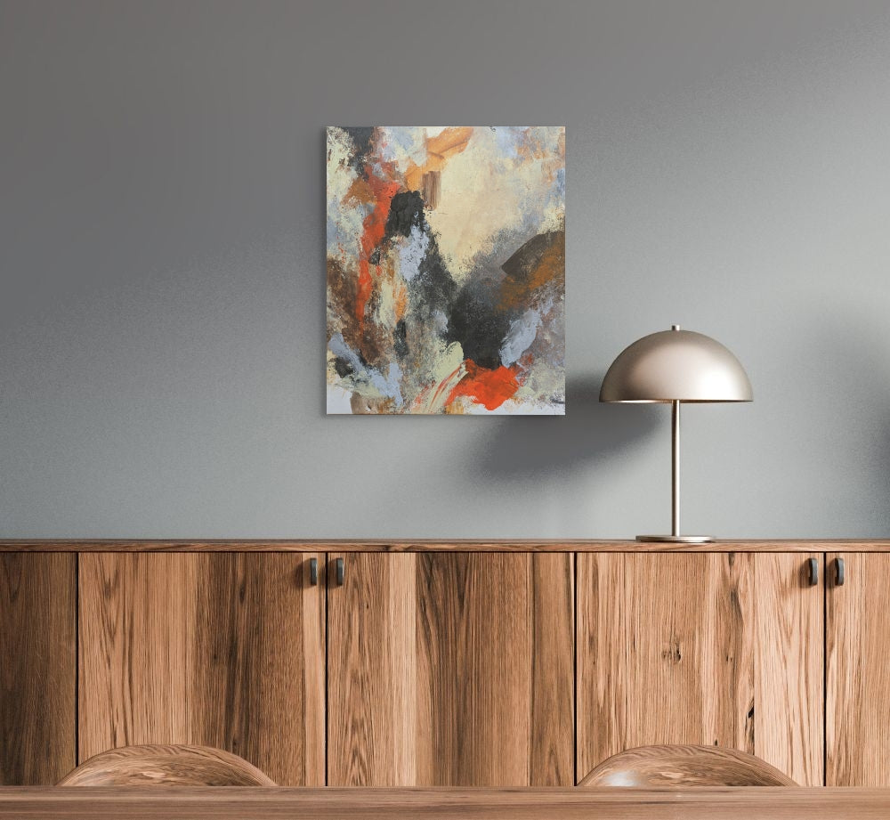 Abstract painting on a gray wall above wooden cabinets with a metallic lamp.