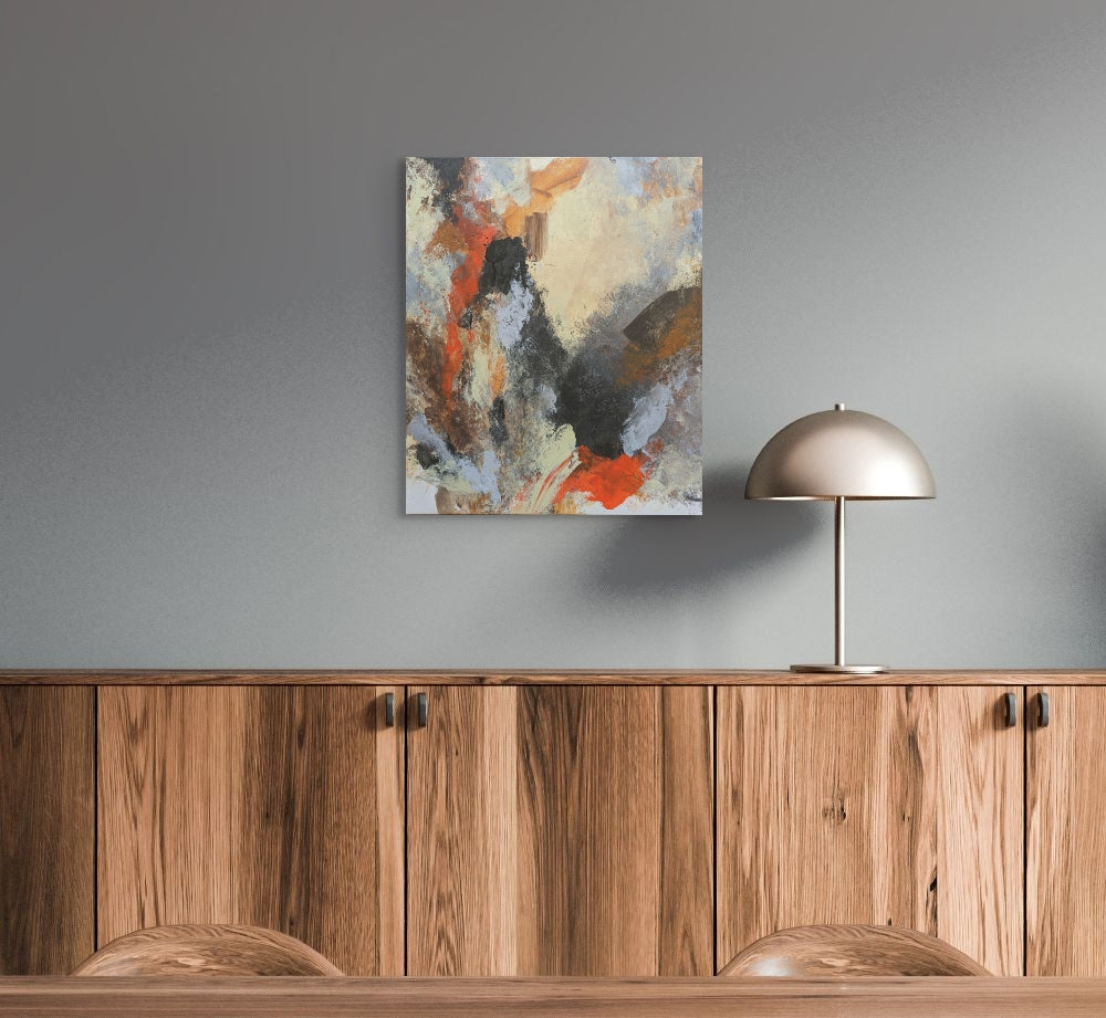 Abstract painting on a gray wall above wooden cabinets with a metallic lamp.