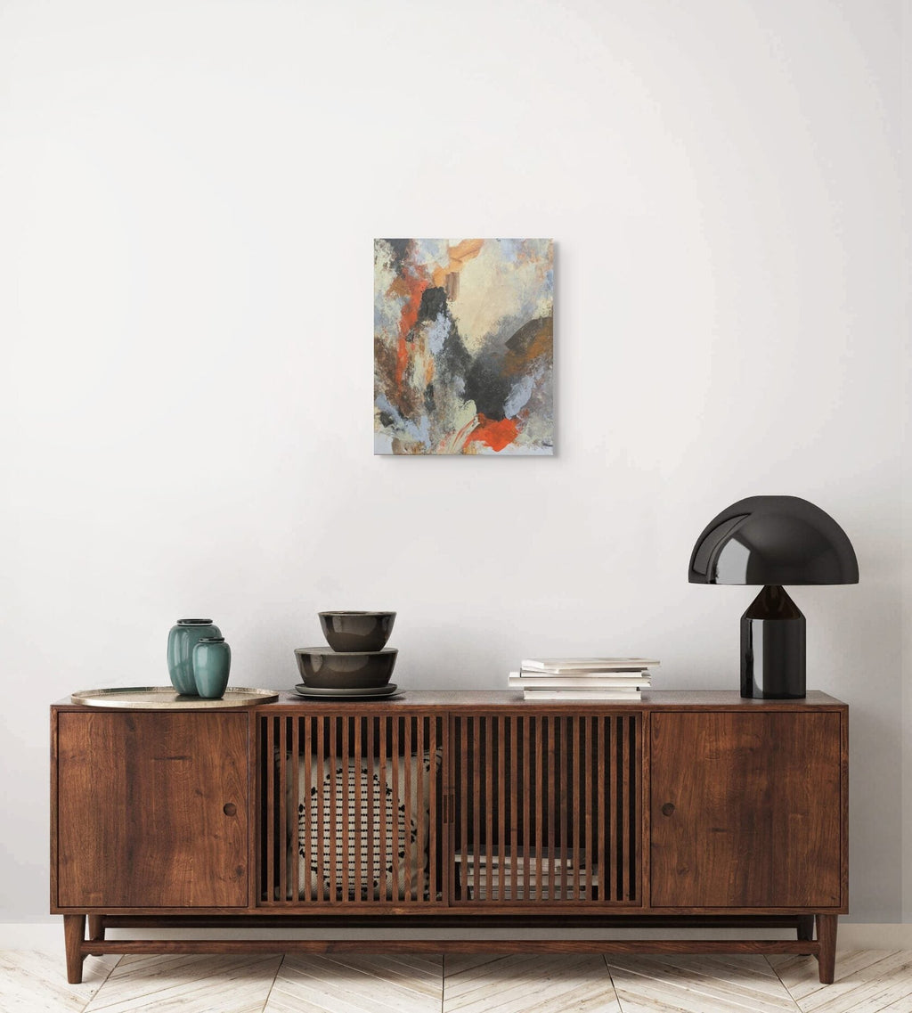 Wooden sideboard with decorative items and a painting on a white wall
