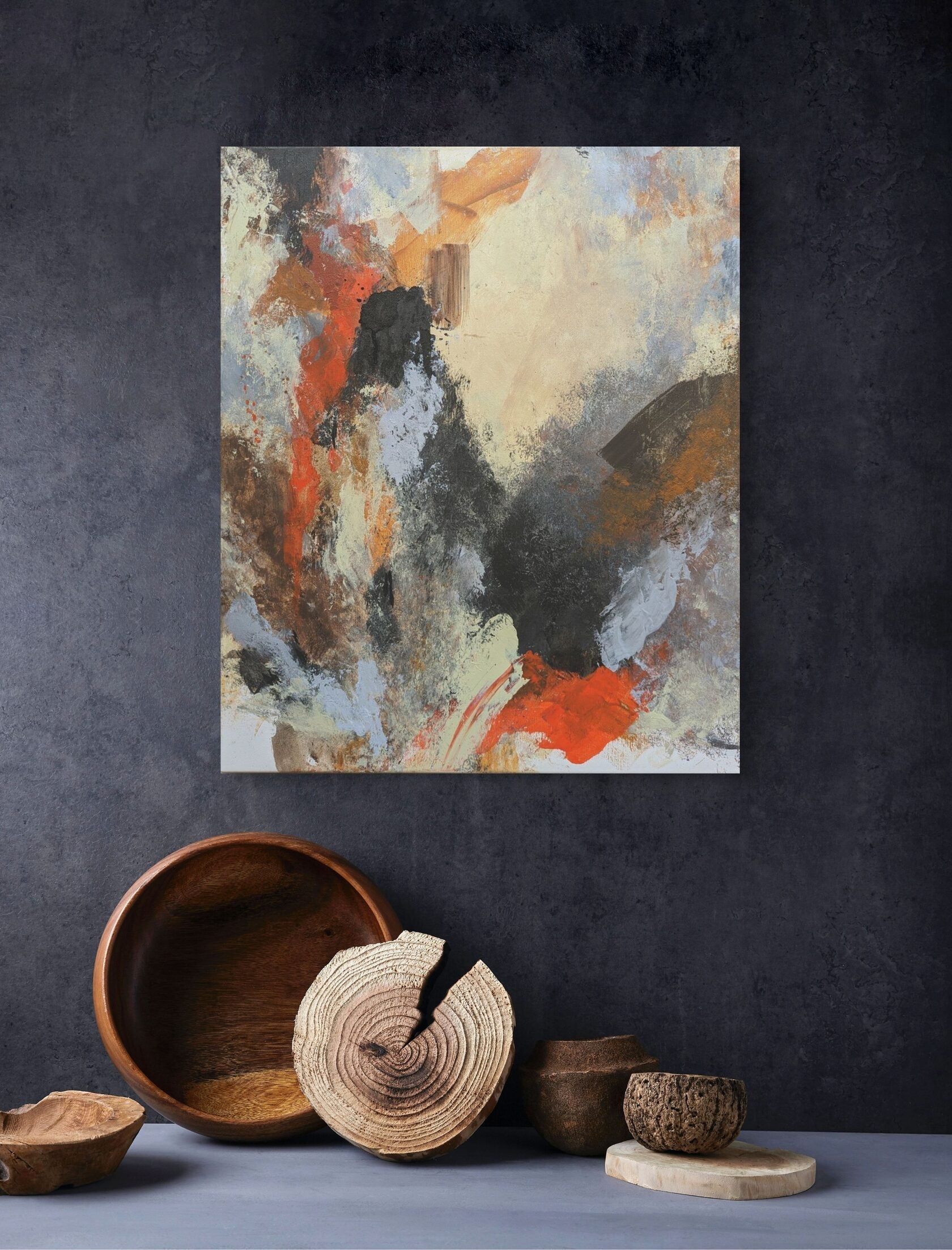Abstract painting on a dark wall with wooden decor items below