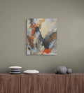 Abstract painting on a wall above a wooden cabinet with decorative items.