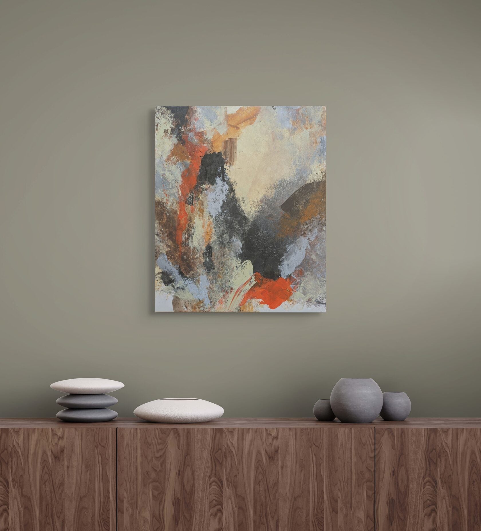 Abstract painting on a wall above a wooden cabinet with decorative items.
