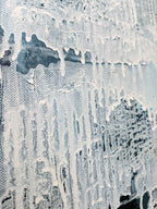 The image is a close-up of a textured surface with a white and black color scheme, featuring a pattern of dripping or dripping paint.