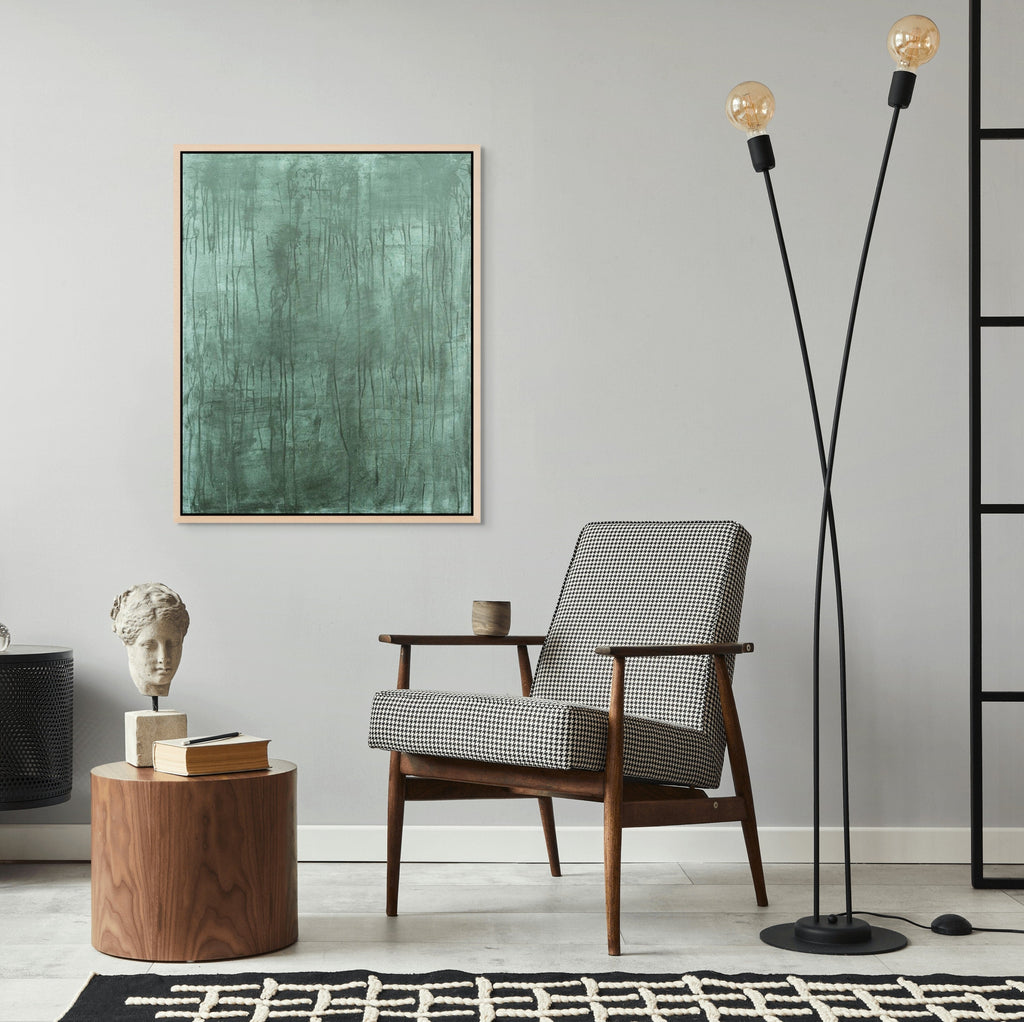 Modern living room with a chair, side table, and floor lamp against a gray wall.