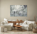 Living room with white sofa, wooden coffee table, and abstract painting on the wall.