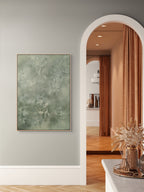 Living room with abstract painting on wall, archway leading to another room.