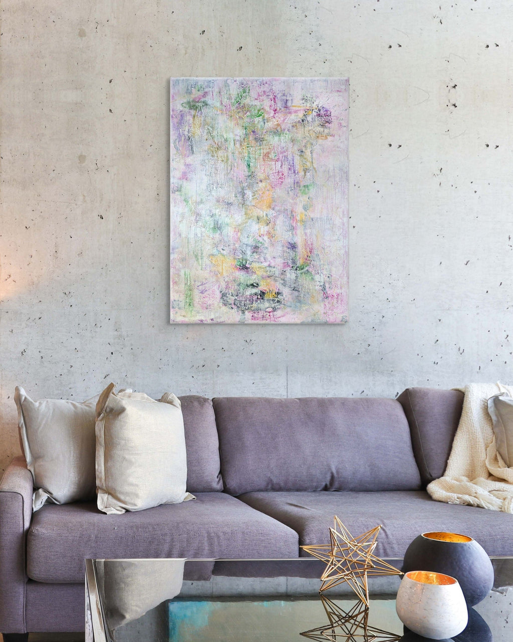 Living room with a gray sofa, abstract painting on the wall, and decorative items.