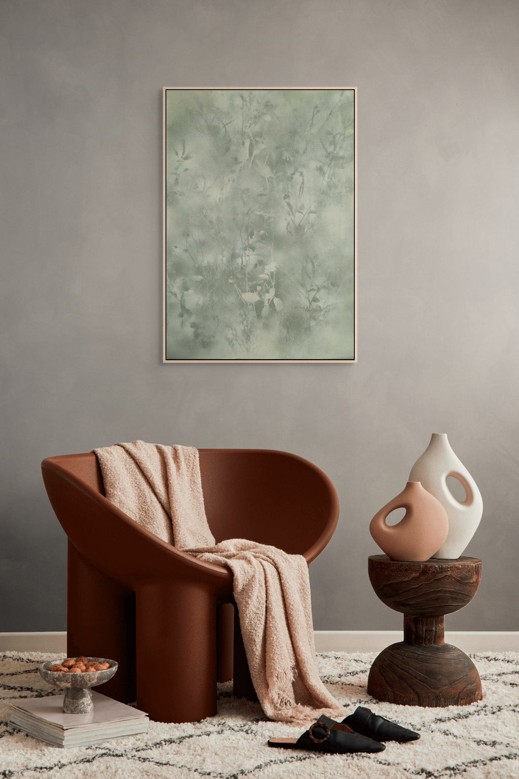 Modern interior with a brown chair, abstract painting, and decorative items.