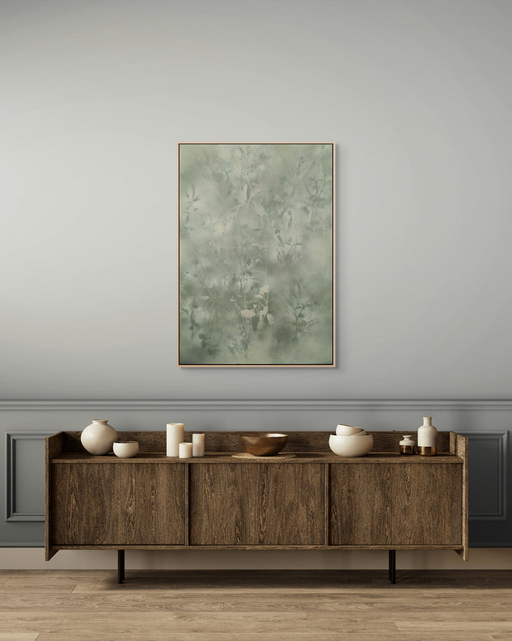 Wooden sideboard with decorative items against a gray wall with a framed abstract painting.