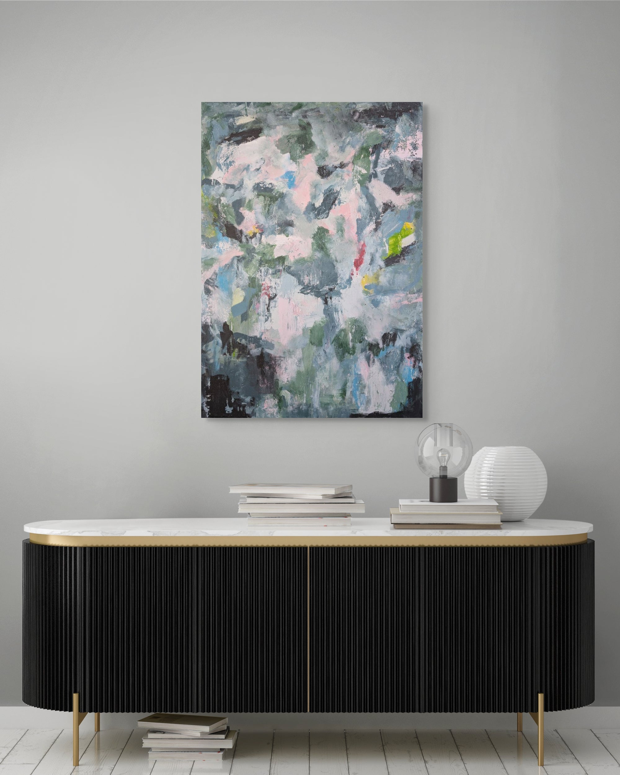 Abstract painting on a gray wall above a black and white console table.